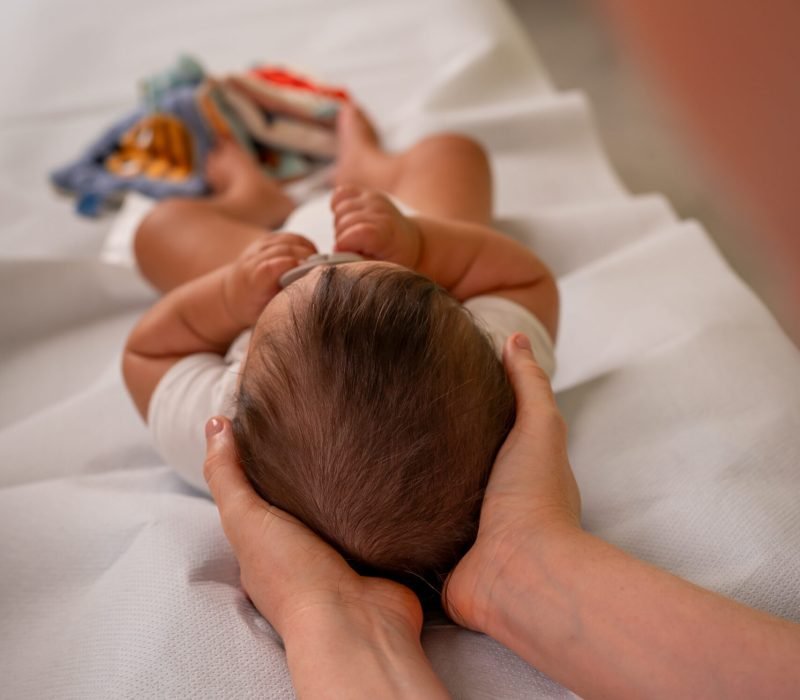 Osteopata D.O. Vittoria Botta esegue trattamento craniale su neonato per torcicollo miogeno. Studio a Collegno.